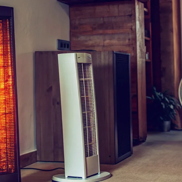 Different types of portable heaters, including a tower heater, placed in a living room.